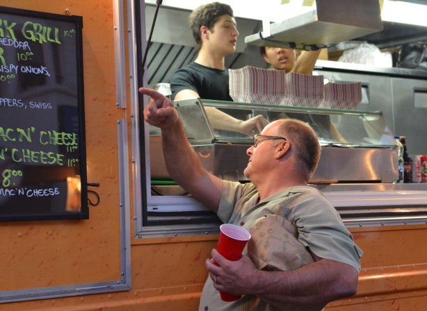 A man is buying food from a food truck