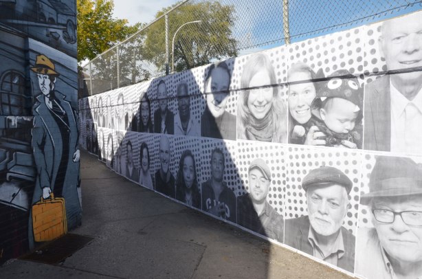 exterior concrete wall covered with black and white photos of people