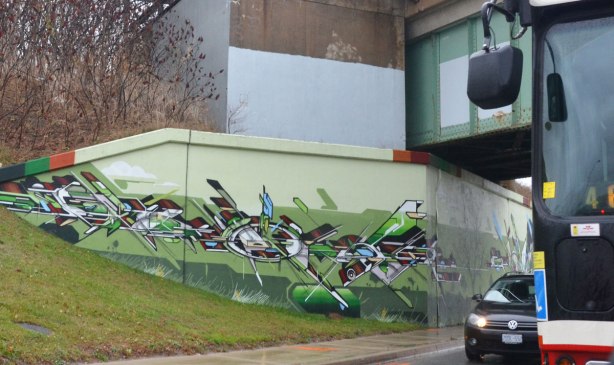 geometric shapes, dynamic shapes, mural on three toned green background on a railway underpass, painted by a group led by IAH Digital (Mediah) on Eglinton Ave