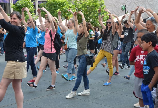 people dancing at Yonge Dundas Square as a group, part of an event called Sharing Dance