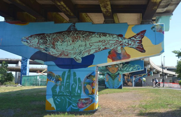 A very large fish is painted across the top of a bent, and a hand is on the vertical part, with finger tips pointed upwards. 