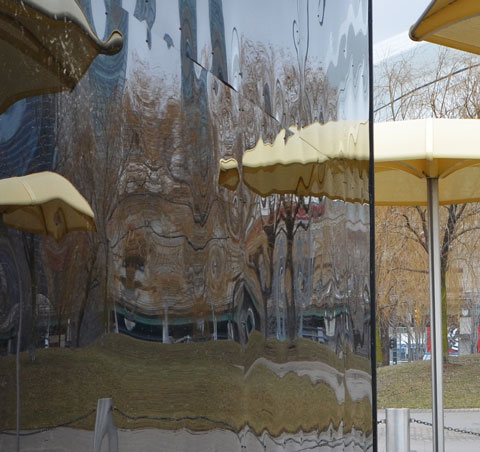 reflections of the yellow umbrellas of H T O beach on the black shiny sides of Icebox, an art installation at the beach 