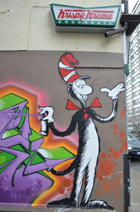 mural of the cat from the cat in the hat, the kids book by Dr. Suess, he's holding a can of spray paint. 
