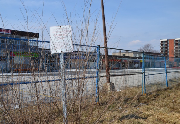 blue wire fence around an empty strip mall 