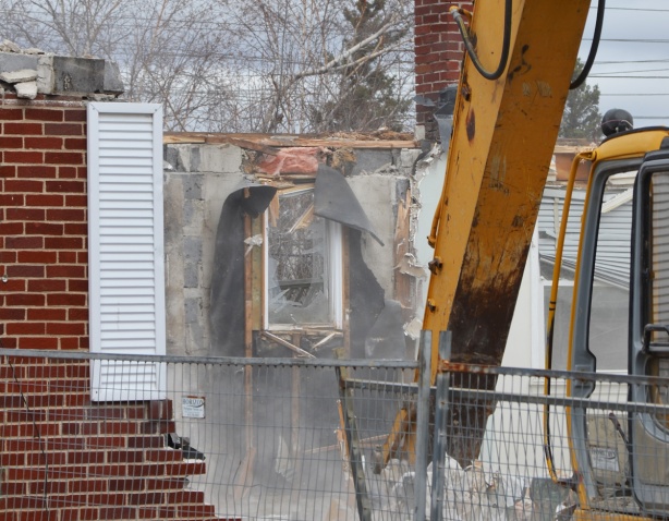 close up of a digger demolishing a house