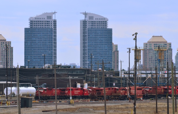 across the tracks, lots of red CPR engines, with skyline behind