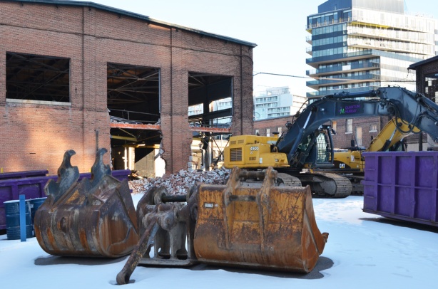 machinery in front of old foundry building that demolition was started on, and then stopped