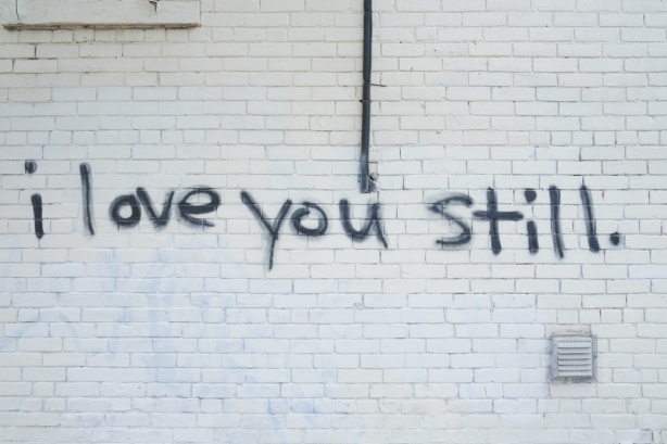 graffiti, black words written on a painted white wall say I love you still