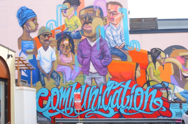 a mural on Queen Street West by elicser titled communications, showing a diverse group of people