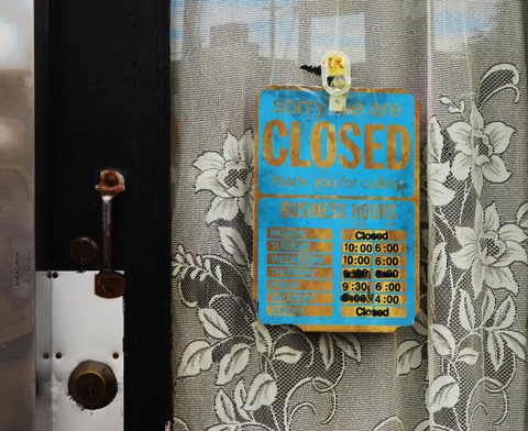 turquoise and gold sign in the window of a door along with a lace curtain, sign says closed