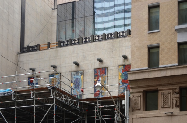 mosaic tile decorations on exterior of building, behind scaffolding