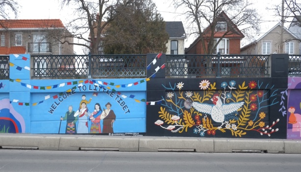 two murals on Lansdowne Ave., on the left is tribute to little tibet, on the right is a white chicken with wings stretched out