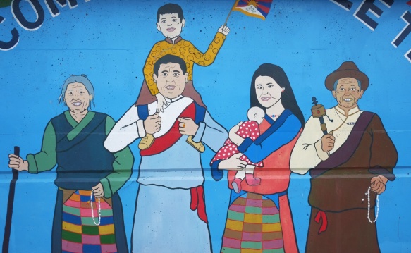 part of a mural, multi generational group of people, little tibet, mother holding baby, father with son on his shoulders, grandparents too