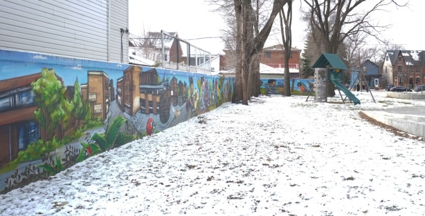 snow covered playground with one wall covered in a mural painted by elicser elliott and nick sweetman