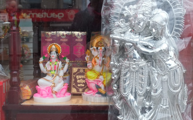 looking in a store window in Little India, figurines, shiny silver statues