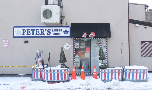 entrance to Peter's Barber Shop, with Toronto Maple Laf theme, in winter, range cones in front of door, planters in red, white, and blue stripes