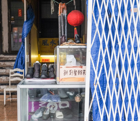 small shoe repair shop on gerrard, umbrellas for sale, red chinese lantern hanging from ceiling