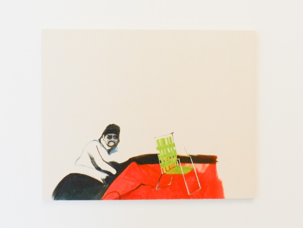 painting on a wall in a gallery, a man in white cap sitting beside a green lawn chair on a red table