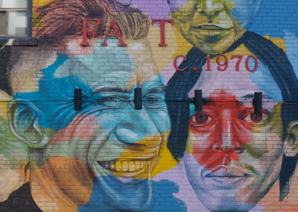 part of Troy Lovegates mural, two faces of young men in a variety of colours