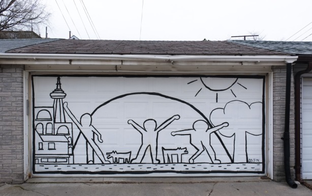 on a white garage door in a lane, a black line drawing of the CN Tower, 3 people dancing, the sun, a tree and two dogs 
