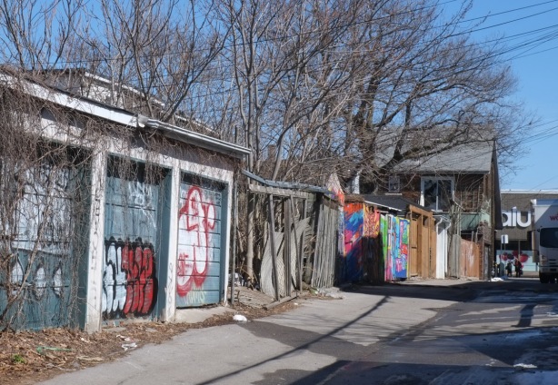 garages on Paul Estrela Lane, some with street art or graffiti on them