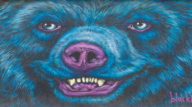 mural by Jeff Blackburn of a large blue bear face with maroon nose and mouth, white teeth, furry, 