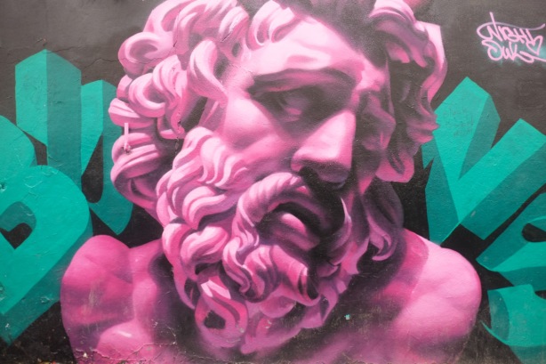 pink portrait of a man with curly hair, curly beard, and a mustache, his eyes are closed 