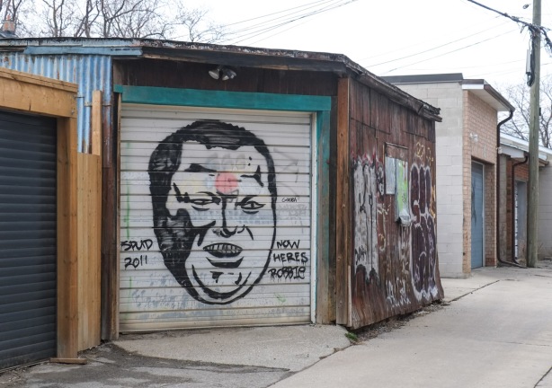 black paint on a white garage door, an old spud bomb painting of Rob Ford, ex-mayor of toronto, painted in 2011