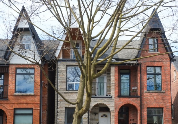 row of two and three storey bay and gable houses, large tree in front
