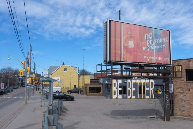 where Sorauren meets Dunda West, a big billbord, an old yellow building, and another building with the words be better written in big white capital letters