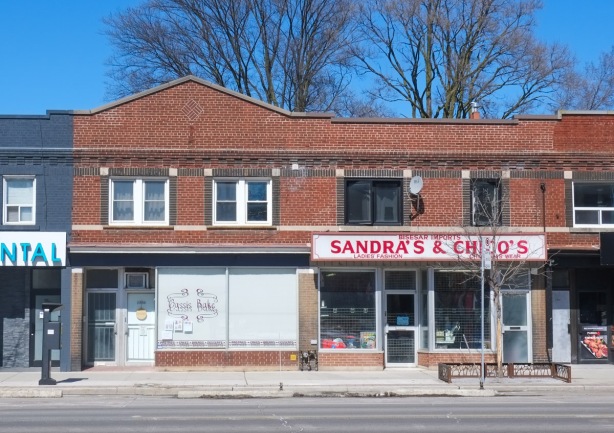 two storey brick store front on danforth, with small peak in roof on on side 