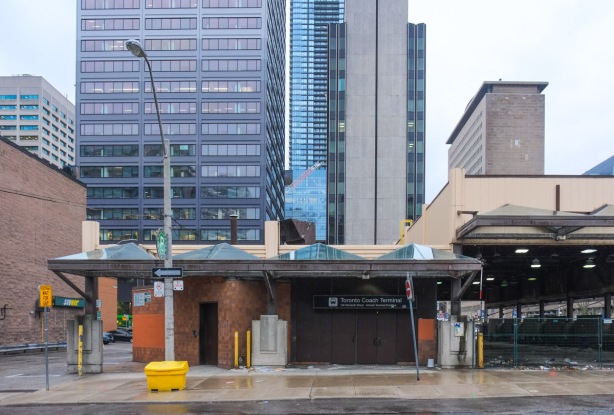 old Toronto coach station, now empty with metal fence blocking entrances, Elizabeth street view, newer high rises in the background