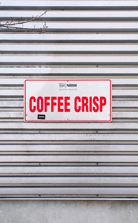 sign on grey corrugated metal wall that says Nestle, coffee crisp 