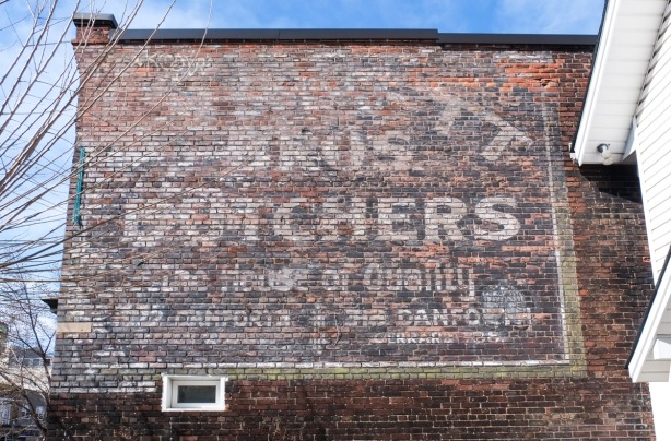 ghost sign for Burnett Brothers Butchers of high quality, on old brick building on the Danforth