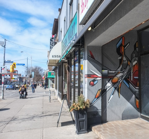 small street art mural by mediah in the entrance to a store, people on the sidewalk, Danforth 