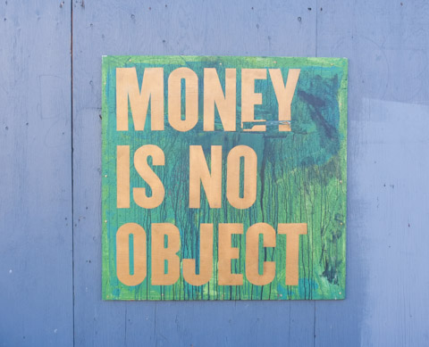 graffiti signs by Nigel Smith, with words that say money is no object